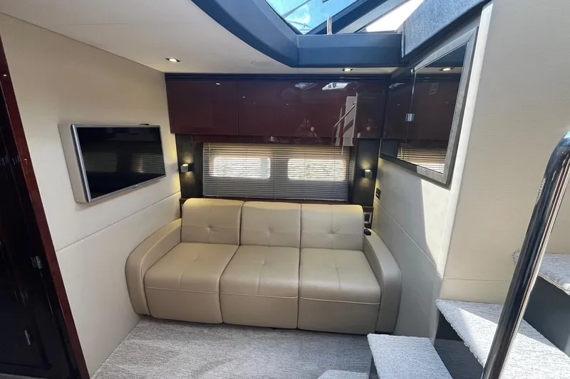 Godsend Yacht Photos Pics Luxurious interior of 2015 Sea Ray 470 Sundancer yacht with beige sofa and TV.