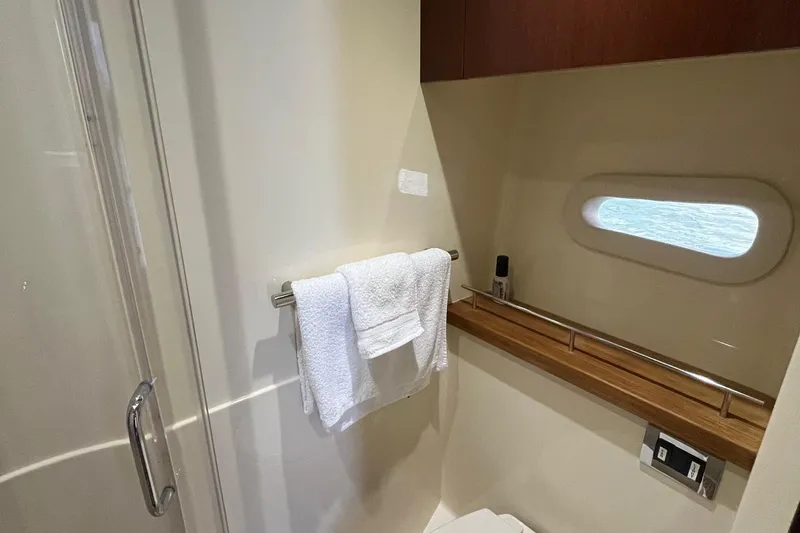Godsend Yacht Photos Pics Luxurious bathroom interior of 2015 Sea Ray 470 Sundancer yacht with towel and window.