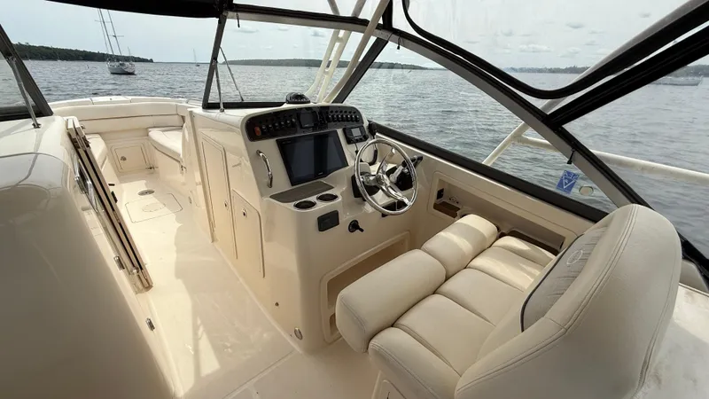 Aletha P Llc Yacht Photos Pics 2016 Grady-White Freedom 307 boat interior with steering wheel and seating, overlooking calm waters.