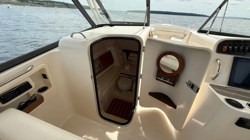 Aletha P Llc Yacht Photos Pics 2016 Grady-White Freedom 307 boat interior with cabin and helm, on calm water.