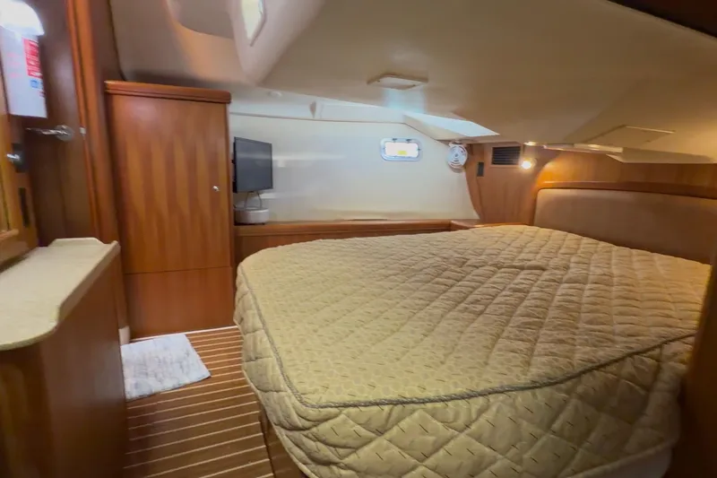 Wailele Yacht Photos Pics Luxurious interior of 2007 Hunter 44 Deck Salon yacht with cozy bed and wooden cabinetry.