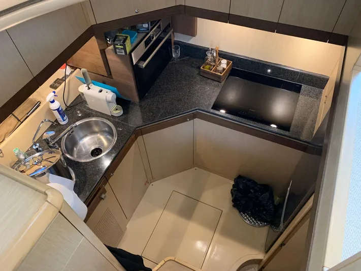  Yacht Photos Pics Compact kitchen area in a 2005 Ferretti Yachts 550, featuring modern appliances and sleek design.