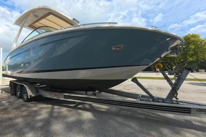  Yacht Photos Pics 2018 Regal 29 OBX boat on trailer, parked outdoors under a cloudy sky.