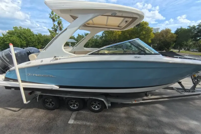  Yacht Photos Pics 2018 Regal 29 OBX boat on trailer, blue hull, parked outdoors.