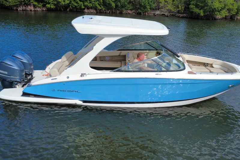  Yacht Photos Pics 2018 Regal 29 OBX boat cruising on a calm waterway with lush greenery.