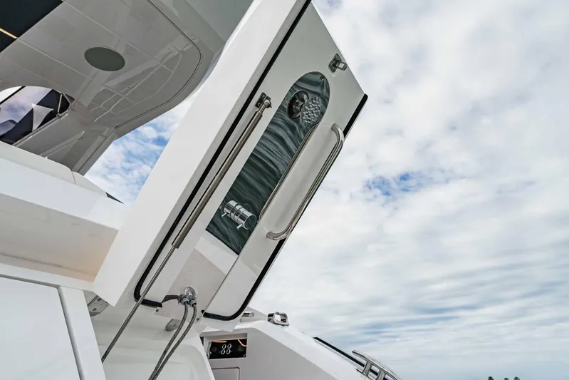  Yacht Photos Pics 2024 Sunseeker Manhattan 55 yacht with open hatch under a cloudy sky.