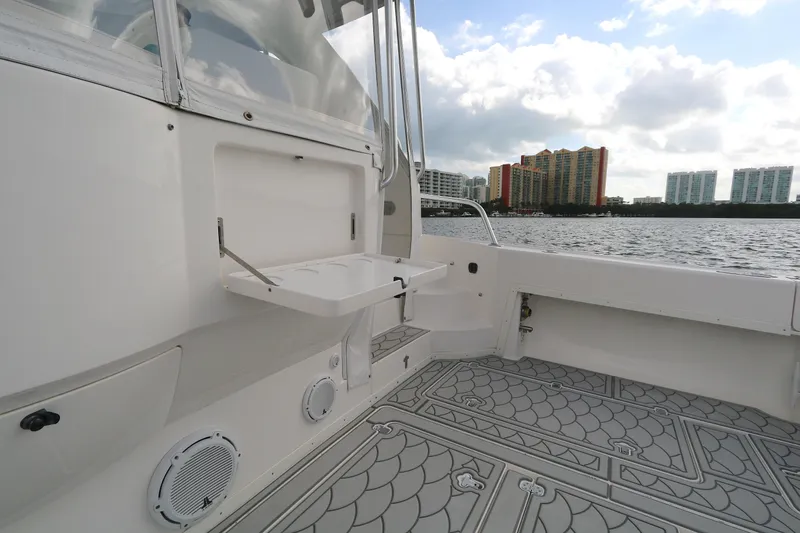  Yacht Photos Pics 2012 Intrepid 475 Sport Yacht deck with foldable table, overlooking waterfront cityscape.
