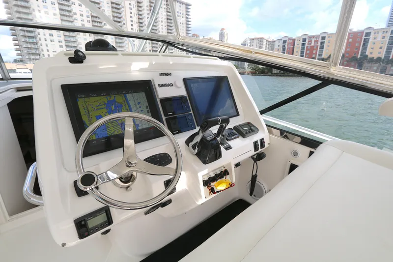  Yacht Photos Pics Helm of 2012 Intrepid 475 Sport Yacht with navigation screens, steering wheel, and cityscape view.