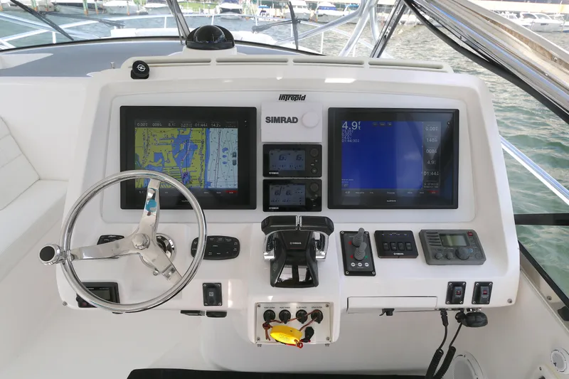  Yacht Photos Pics Control panel of a 2012 Intrepid 475 Sport Yacht with navigation screens and steering wheel.