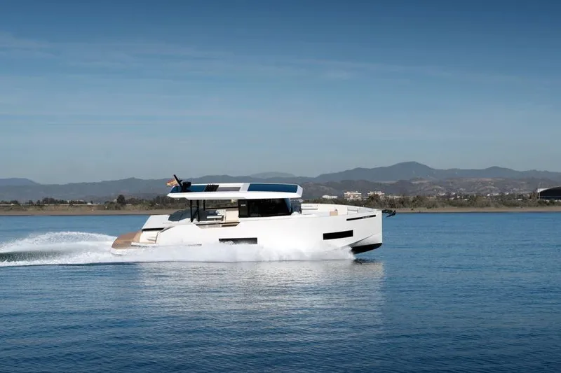  Yacht Photos Pics 2025 De Antonio Yachts D50 cruising on a serene lake with mountainous backdrop.