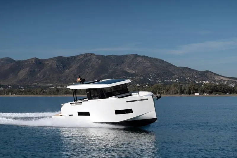  Yacht Photos Pics 2025 De Antonio Yachts D50 cruising on a serene lake with mountainous backdrop.