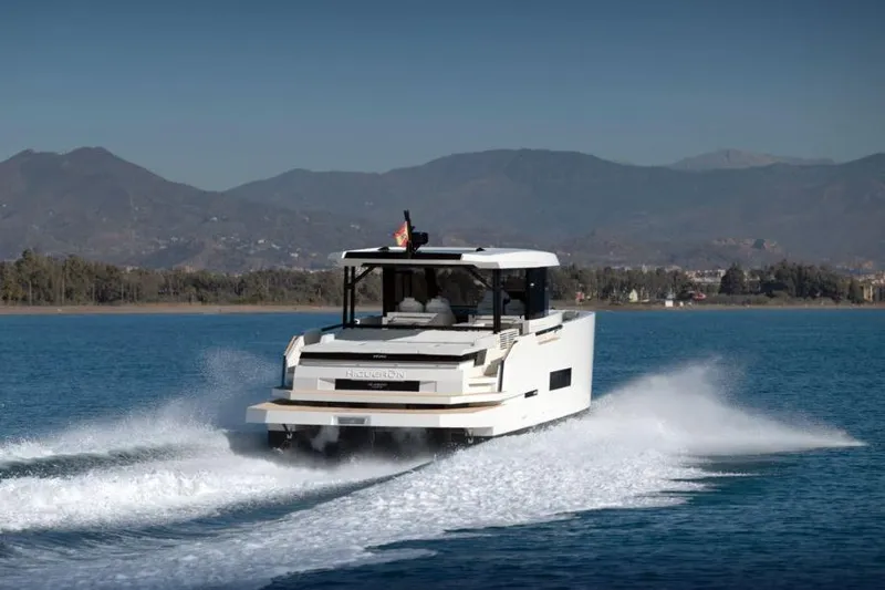  Yacht Photos Pics 2025 De Antonio Yachts D50 cruising on a serene lake with mountainous backdrop.