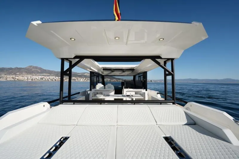  Yacht Photos Pics 2025 De Antonio Yachts D50 luxury yacht on calm sea with scenic coastal backdrop.