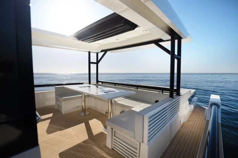  Yacht Photos Pics Luxurious 2025 De Antonio Yachts D50 with spacious deck and modern seating, overlooking the ocean.