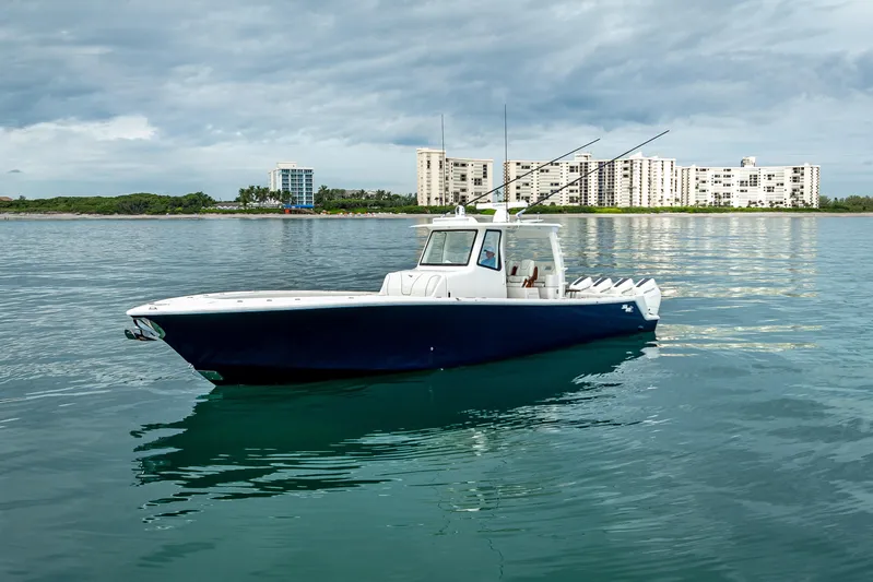  Yacht Photos Pics 2024 SeaVee 420Z boat on calm water with cityscape background.