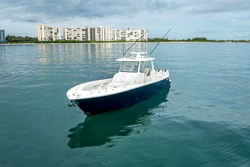  Yacht Photos Pics 2024 SeaVee 420Z boat on calm water with cityscape background.