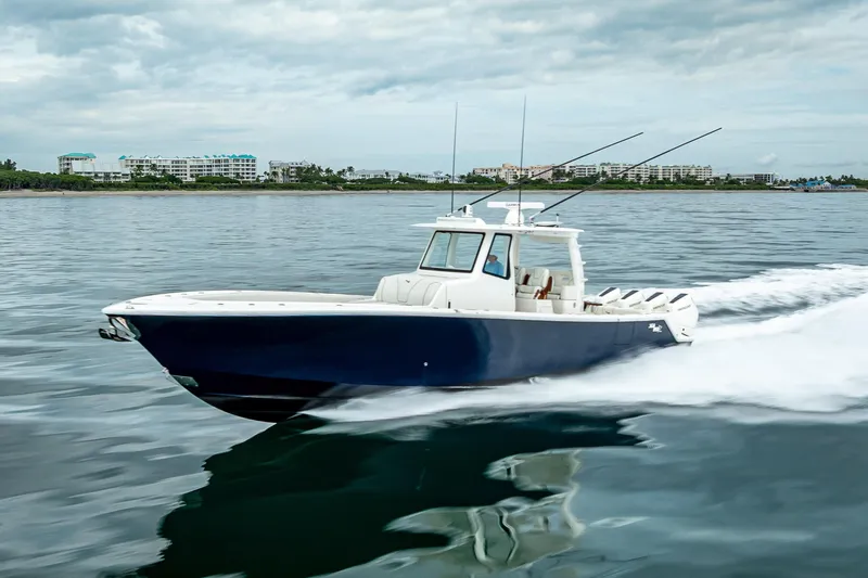  Yacht Photos Pics 2024 SeaVee 420Z boat cruising on calm waters near coastal buildings.