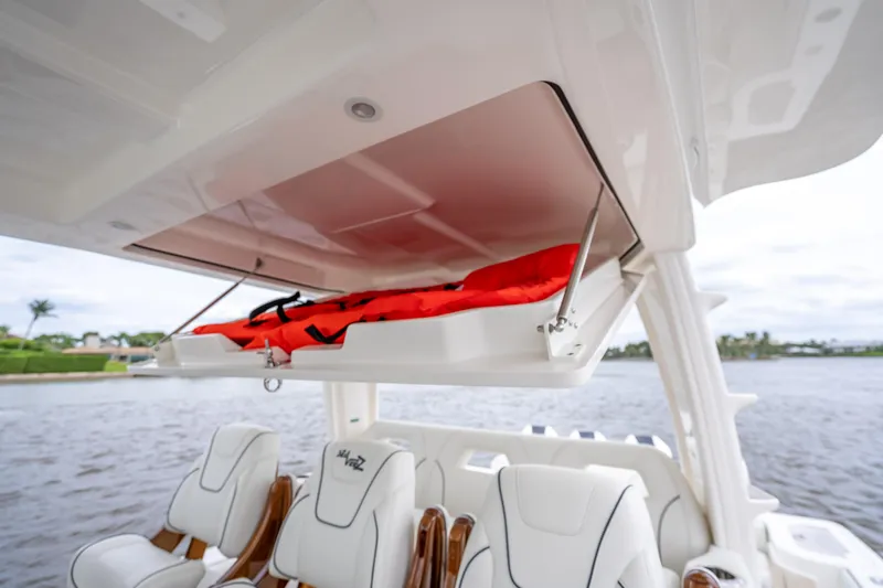  Yacht Photos Pics 2024 SeaVee 420Z boat with open storage compartment and life jacket, featuring luxurious seating.