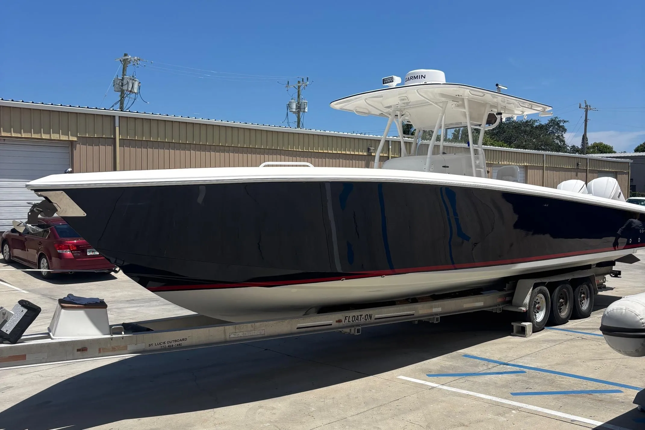 2005 Venture boat on trailer in sunny outdoor storage area.