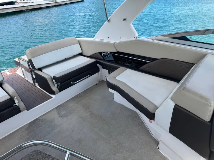 Yacht Photos Pics 2013 Regal 3200 Bowrider interior with comfortable seating, docked by clear blue water.