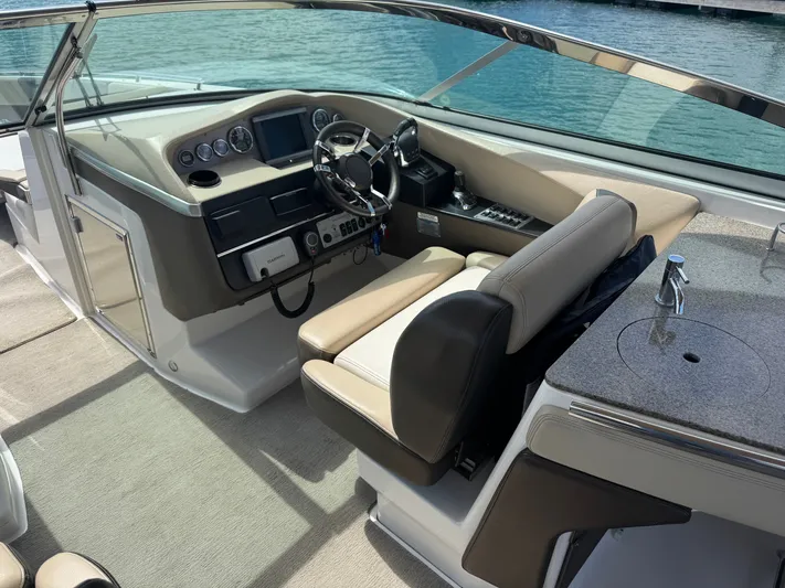  Yacht Photos Pics 2013 Regal 3200 Bowrider cockpit with steering wheel, dashboard, and sink by the water.