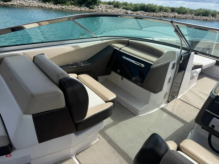  Yacht Photos Pics 2013 Regal 3200 Bowrider interior with beige and black seating, near a scenic waterway.