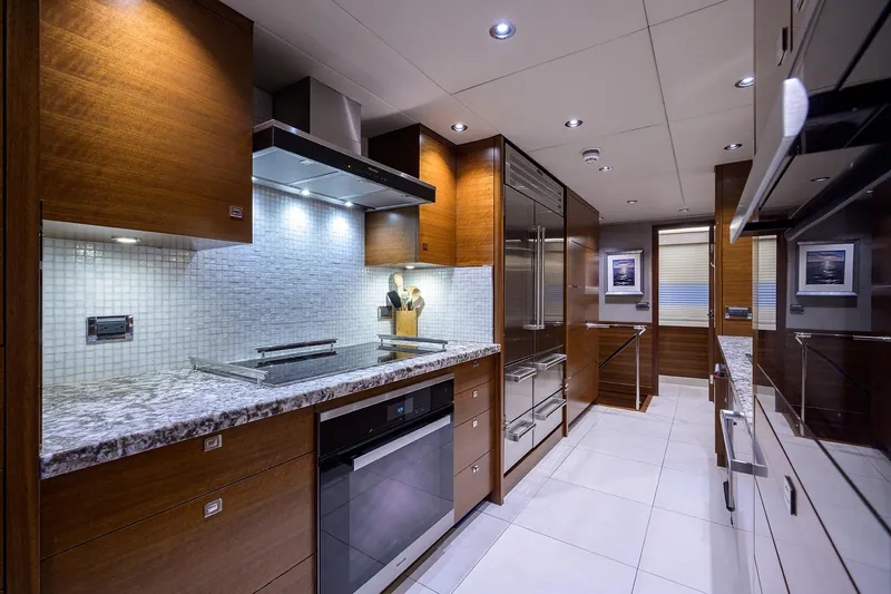 Lacey Kay Yacht Photos Pics Luxurious kitchen interior of 2017 Nordhavn 96 yacht with modern appliances and wooden cabinetry.