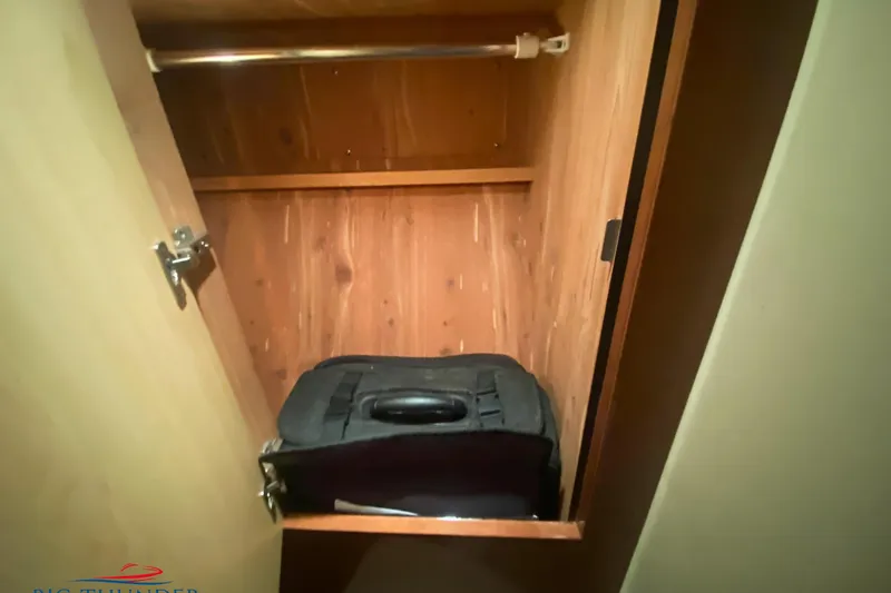  Yacht Photos Pics Wooden closet interior on a 2007 Sea Ray 52 Sundancer yacht with a suitcase inside.