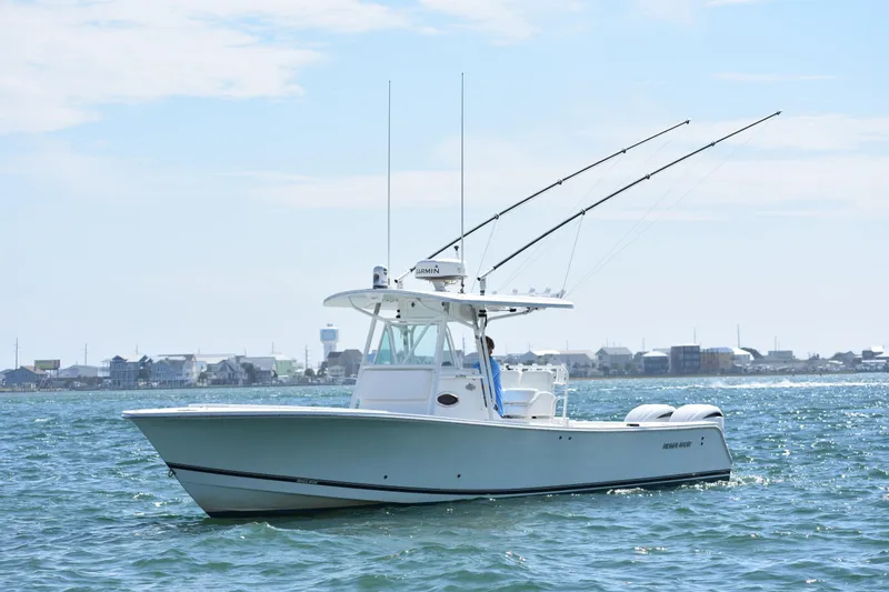  Yacht Photos Pics 2008 Regulator 32 Forward Seating boat on water with fishing rods, coastal background.