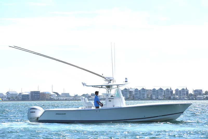  Yacht Photos Pics 2008 Regulator 32 Forward Seating boat cruising on water near coastal buildings.