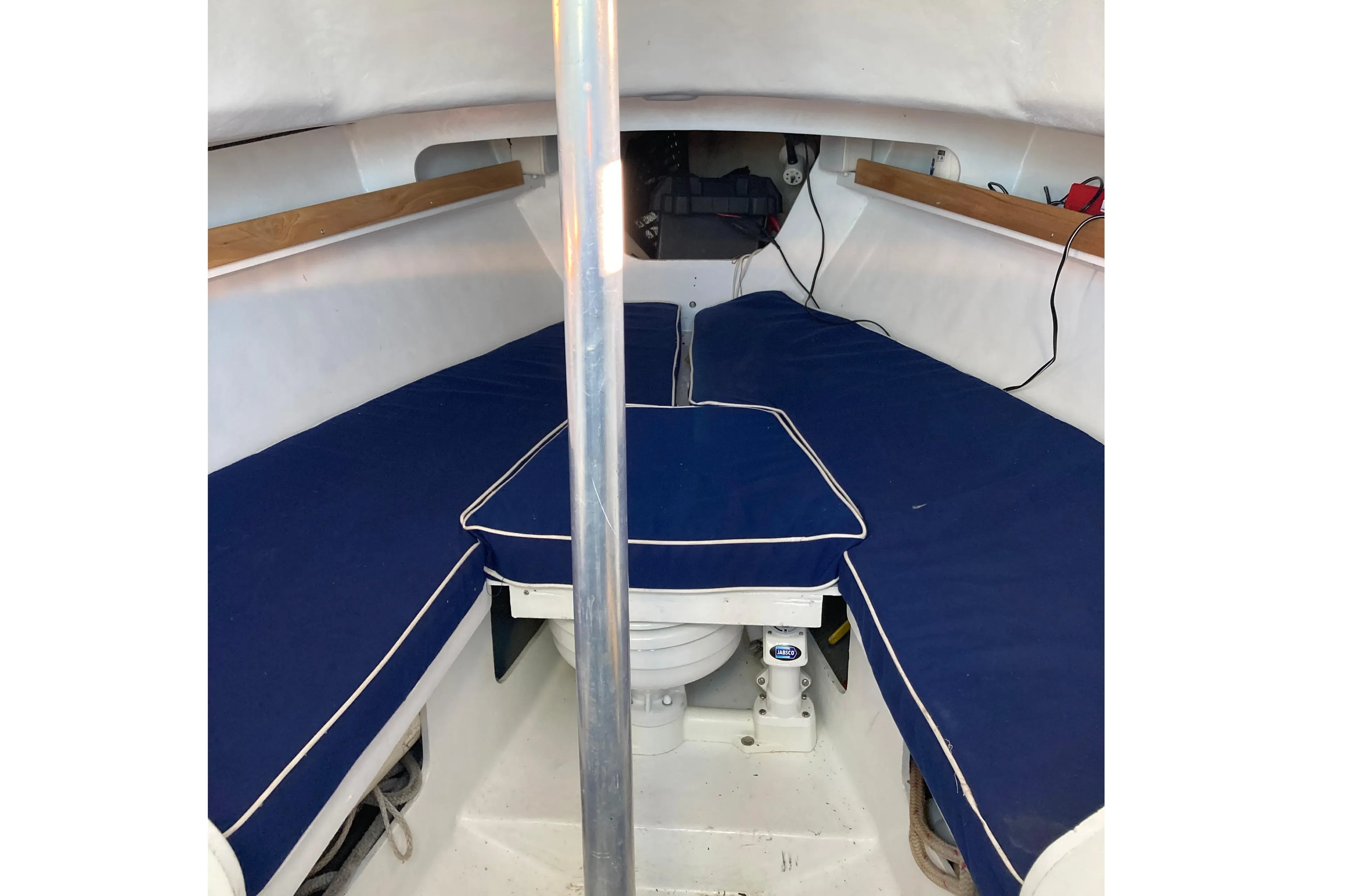 Interior of a 1964 Pearson Commander sailboat with blue cushioned seating.