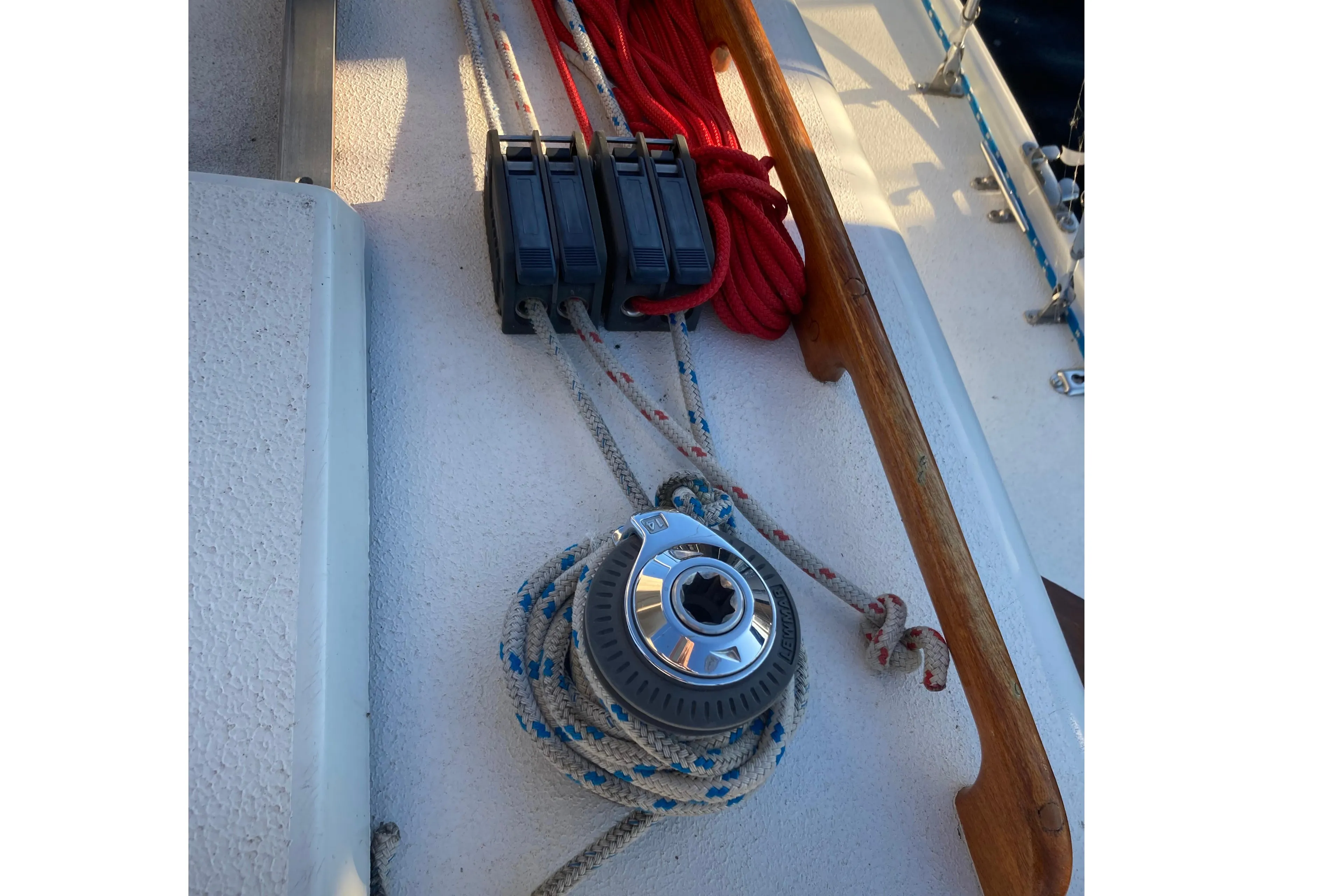 Deck of 1964 Pearson Commander sailboat with winch, ropes, and cleats.