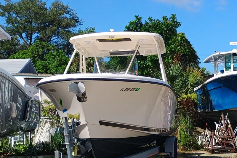 280-117 Brokerage Joe Yacht Photos Pics 2010 Pursuit S 280 Sport boat on trailer, surrounded by trees and other boats.