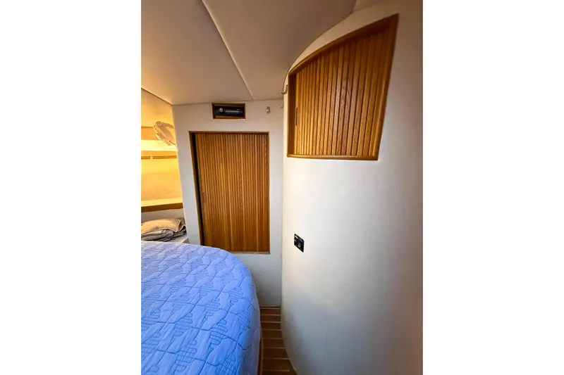  Yacht Photos Pics Interior of 1987 Bertram 37 Convertible yacht with wooden accents and blue bedding.