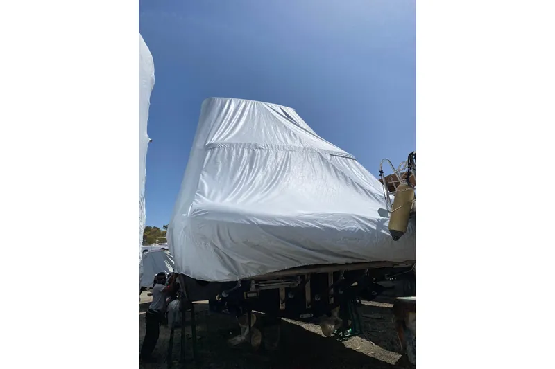  Yacht Photos Pics 1987 Bertram 37 Convertible boat covered with protective tarp under clear blue sky.