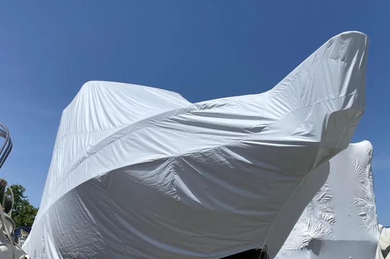  Yacht Photos Pics 1987 Bertram 37 Convertible boat covered with white tarp under clear blue sky.