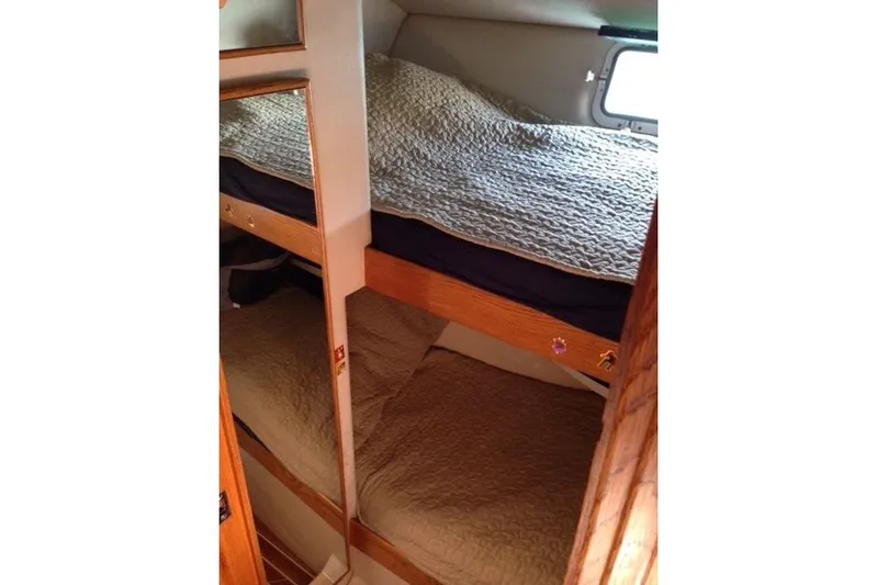  Yacht Photos Pics 1987 Bertram 37 Convertible cabin with cozy bunk beds and wooden interior.