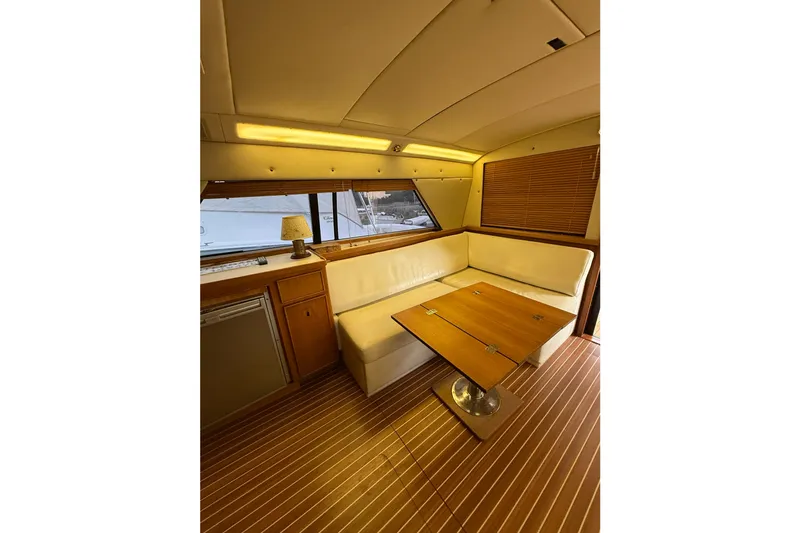  Yacht Photos Pics Interior of 1987 Bertram 37 Convertible yacht with cozy seating and wooden table.