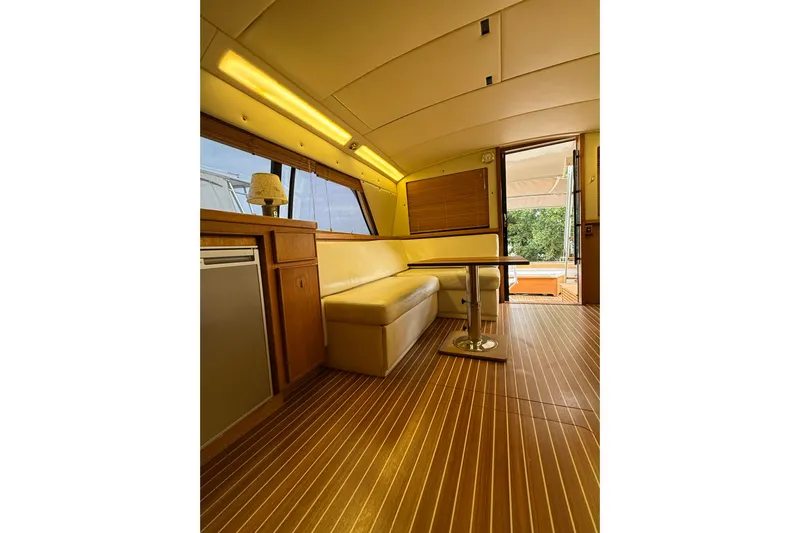  Yacht Photos Pics Interior of 1987 Bertram 37 Convertible yacht with wooden flooring and cozy seating area.