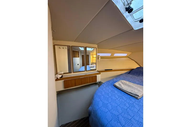  Yacht Photos Pics Interior cabin of 1987 Bertram 37 Convertible yacht with blue bedding and mirror.