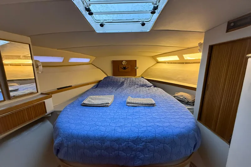  Yacht Photos Pics Cozy cabin interior of 1987 Bertram 37 Convertible with blue bedding and skylight.