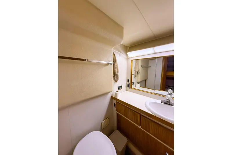  Yacht Photos Pics 1987 Bertram 37 Convertible yacht bathroom with sink, mirror, and towel rack.