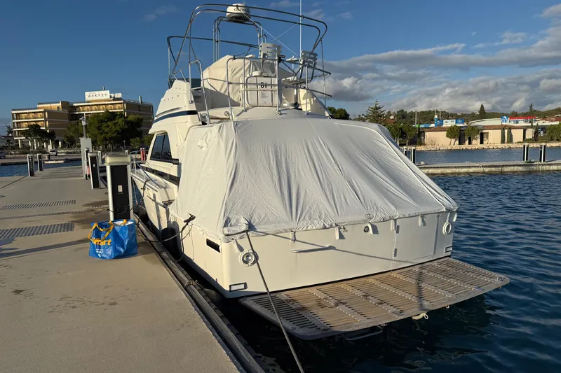  Yacht Photos Pics 1987 Bertram 37 Convertible yacht docked, covered, with clear skies and waterfront view.