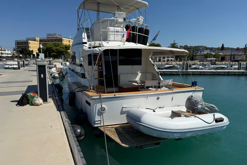  Yacht Photos Pics 1987 Bertram 37 Convertible yacht docked with inflatable boat, sunny marina setting.