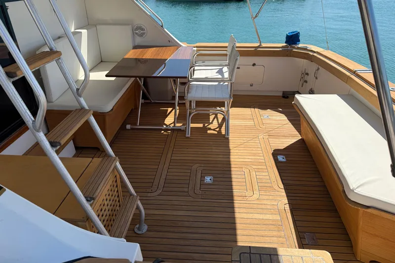  Yacht Photos Pics 1987 Bertram 37 Convertible yacht deck with seating and table, overlooking water.