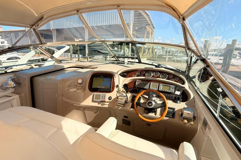 Banking Memories Yacht Photos Pics 2001 Sea Ray 410 Express Cruiser helm with modern navigation equipment and wooden steering wheel.