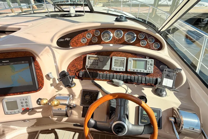 Banking Memories Yacht Photos Pics Control panel of a 2001 Sea Ray 410 Express Cruiser with navigation instruments and steering wheel.
