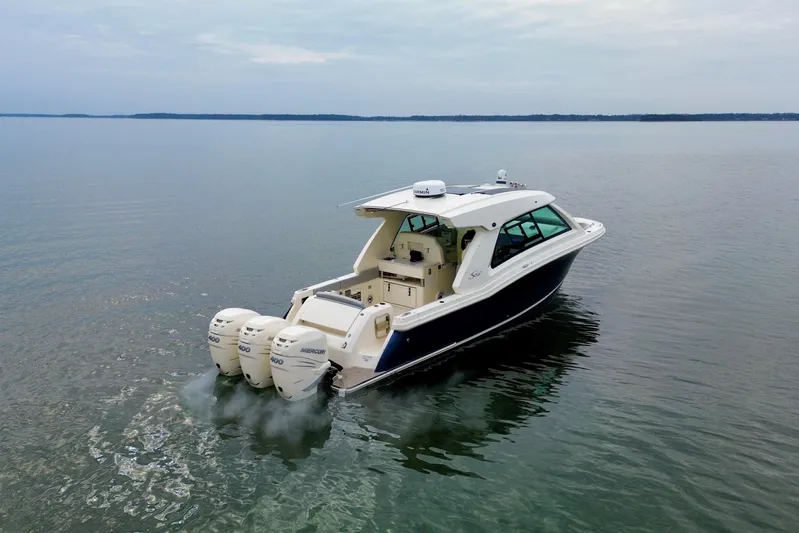  Yacht Photos Pics 2023 Scout 350 LXZ boat cruising on calm waters with triple Mercury engines.