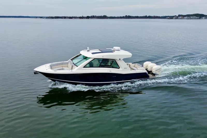  Yacht Photos Pics 2023 Scout 350 LXZ boat cruising on calm water, showcasing sleek design and powerful engines.
