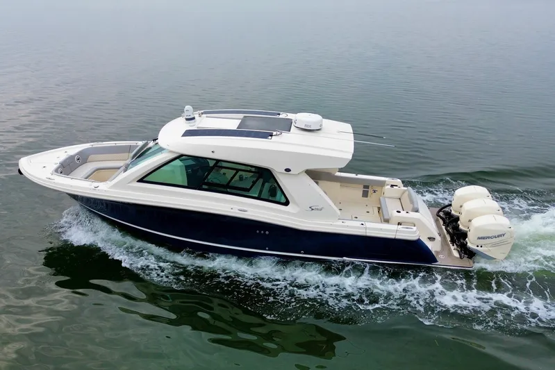  Yacht Photos Pics 2023 Scout 350 LXZ boat cruising on calm water, featuring triple Mercury engines.